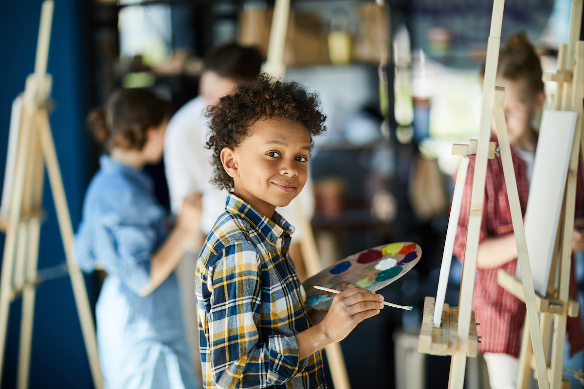 Young boy at easel, painting